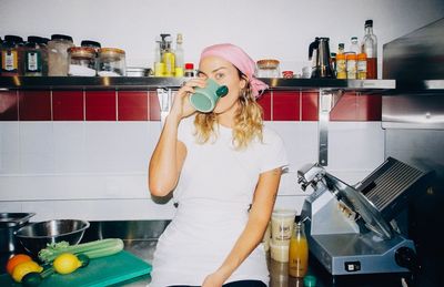 Sinead McInerney in a long winter coat and white headscarf at the RIPE Europe Berlin pop-up hatch, snow on the ground, 'WARM YUMMY BROTH' signs in the window